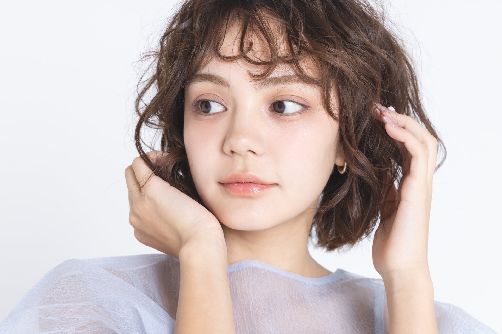 細かな筋感が分かるようにハイライト後の髪表面を指先で整えている様子